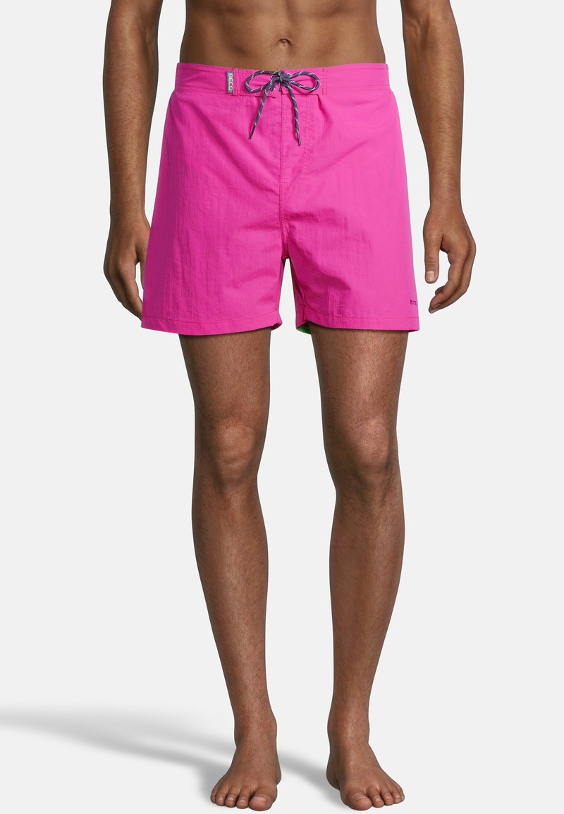 Shorts de bain roses en tissu léger. Équipés d'une taille élastique avec cordon de serrage et d'un design simple et structuré.