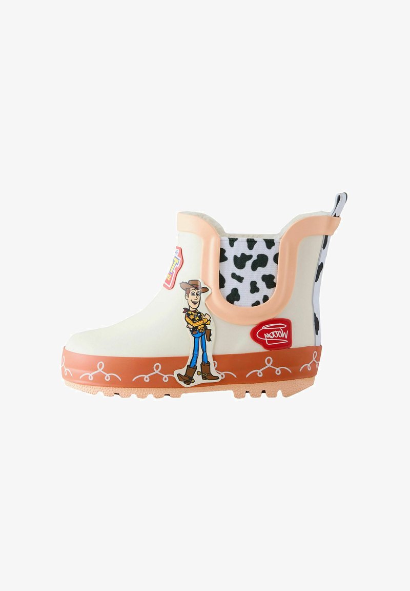Gyermek esőcsizma Toy Story cowboy karakterrel, bézs felsőrész, narancssárga talp fehér díszítő vonalakkal, valamint fekete-fehér tehénmintás elasztikus oldalakkal.