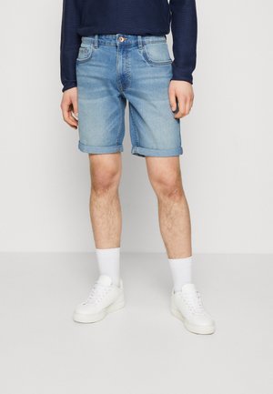 Ljust blå denimshorts med upplagda muddarna, fem fickor och knappstängning. Stylar med vita sneakers och strumpor.