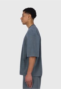Grå kortærmet t-shirt lavet af blød bomuld, med rund hals, en brystlomme og en afslappet pasform, i et enkelt design.