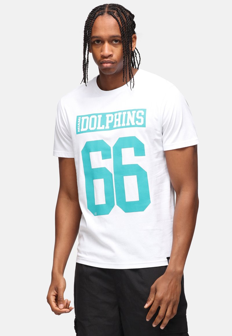 Camiseta blanca de algodón con un gráfico en color teal que dice "MIAMI DOLPHINS" y "66" en grandes números. Diseño de mangas cortas y cuello redondo.