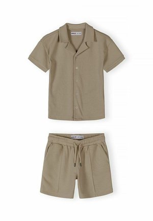 Beżowa koszula na krótki rękaw z kołnierzykiem i pasujące szorty ze ściągaczem, wykonane z lekkiej tkaniny o fakturze.