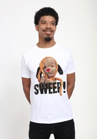 Bílý bavlněný tričko s grafikou plyšového psa s hnědou texturou a černýma ušima, zdobeného preclíky; tučný černý text hlásí "SWEEP!"