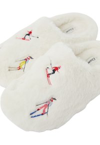 Białe futrzane kapcie z haftowanymi postaciami narciarzy w kolorach czerwonym, czarnym, żółtym i niebieskim. Miękka faktura z zamkniętą piętą.