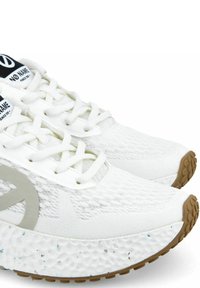 Scarpe da ginnastica bianche con tomaia in mesh testurizzato, un grande logo grigio e una suola intermedia bianca maculata con suola in gomma.