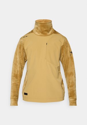 Dlouhý rukáv turtleneck top v hořčicově žluté barvě, vyrobený z hladkého materiálu na těle a texturovaných rukávech, s kapsou na zip na hrudi a logem.
