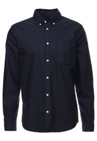 Granatowa koszula zapinana na guziki z długim rękawem, wykonana z bawełny, z kieszenią na piersi, białymi guzikami i klasycznym kołnierzykiem.