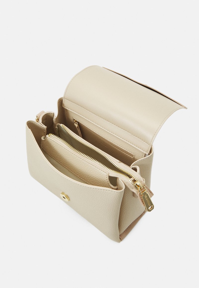 Sac à main en cuir beige avec une finition lisse, ferrures en or, fermeture à pression extérieure et plusieurs poches zippées intérieures.