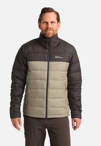 Veste rembourrée avec un col haut, présentant un design bicolore en gris foncé et beige, fabriquée en matière lisse et légère. Fermeture éclair à l'avant.