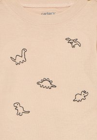 Beige-Stoff mit kleinen, schwarzen Konturzeichnungen von Dinosauriern, darunter Brontosaurus, Pterodaktylus, Stegosaurus, T-Rex und Triceratops.