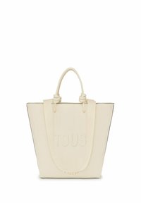 Bolso tote de color marfil con el logo "TOUS" en relieve, que cuenta con asas resistentes, un diseño estructurado y un ribete negro en contraste.