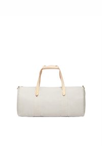 Borsa da viaggio in tela beige con manici in pelle doppi, chiusura a zip e corpo in tessuto. Presenta cuciture visibili e una forma cilindrica.
