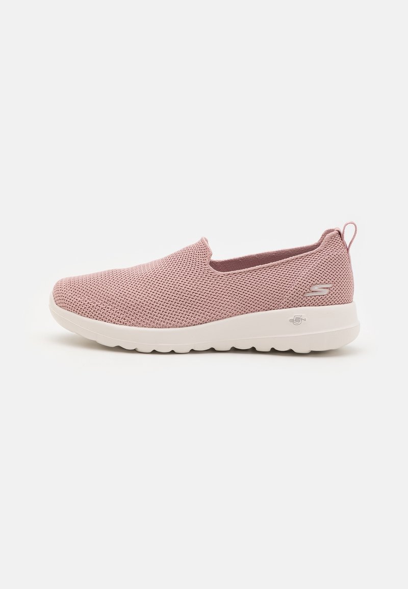 Zapatilla rosa de malla sin cordones con suela blanca, que presenta una parte superior texturizada y una pequeña lengüeta en la parte posterior para facilitar el calzado.
