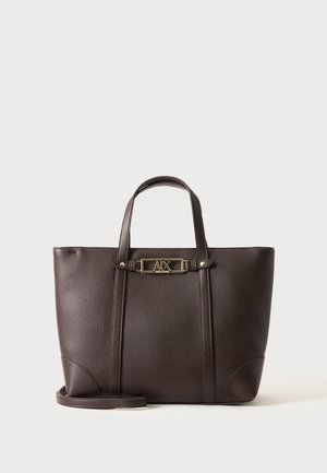 Sac cabas en cuir marron foncé avec deux anses et une plaque logo rectangulaire dorée au centre devant.