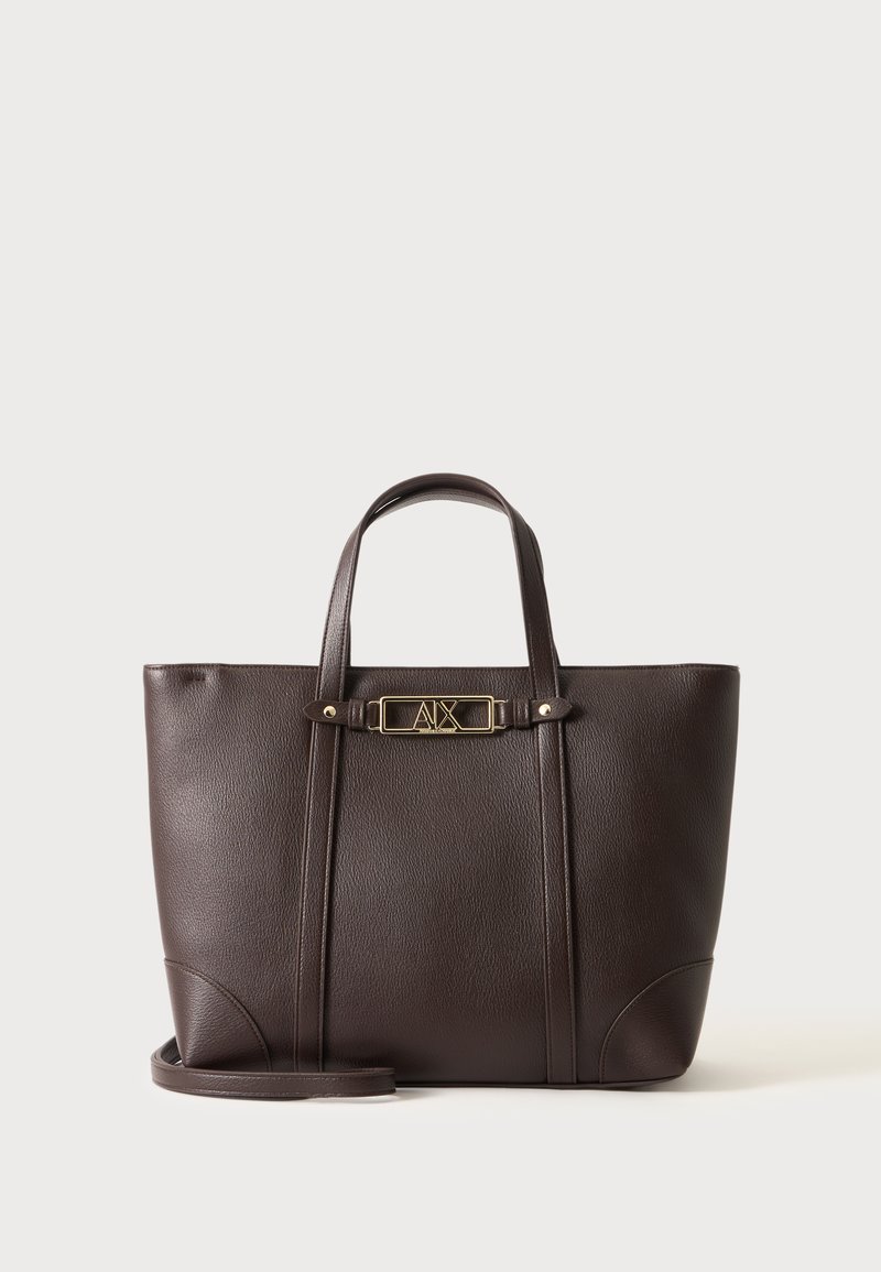 Sac cabas en cuir marron foncé avec deux anses et une plaque logo rectangulaire dorée au centre devant.