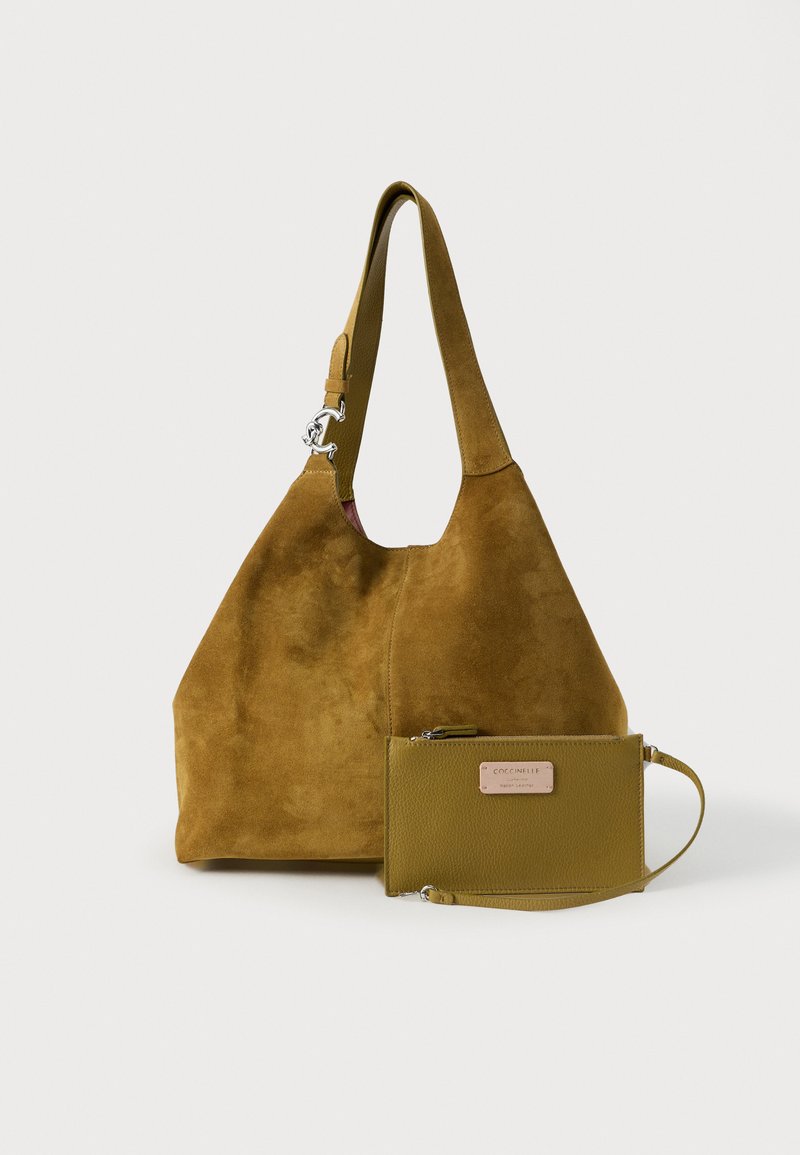 Suède hobo tas in mosterdkleur met een enkele riem, voorzien van een klein bijpassend leren zakje met een metalen merkteken.