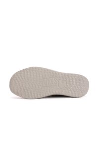 Zool van een sneaker, genuanceerd rubber in lichtgrijs, met een patroonoppervlak en een reliëflogo met de tekst "WALKIN PITAS" en een kipicoon.
