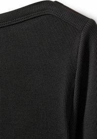 Must mustriga kangast top, ümarate õlgadega ja nähtavate õmblustega. Tekstuur on pehme, luues õrna vertikaalse mustri.