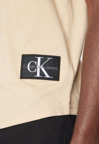 Calvin Klein Jeans BADGE TURN UP SLEEVE - T-shirt basic - warm sand
