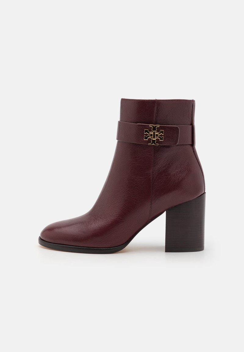 Bottine femme en cuir bordeaux foncé avec talon bloc et logo décoratif doré sur la bride près du haut.