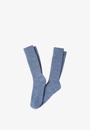 Paire de longues chaussettes bleues tricotées avec des bords côtes, posées à plat sur un fond blanc.