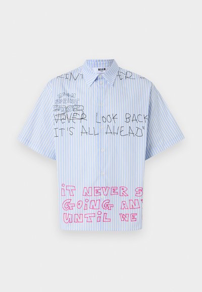 Chemise à manches courtes rayée bleu et blanc avec un texte manuscrit en noir et rose disant "Ne jamais regarder en arrière, tout est devant" et des lettres roses partielles en dessous.