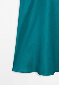Teal blue fabric with a soft, smooth texture and slight draping along the edge.