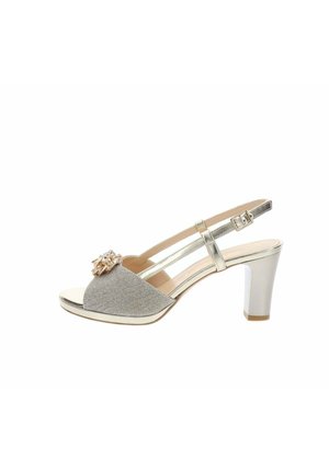 Escarpin argenté à bout ouvert avec bride arrière, brides métalliques, talon bloc de hauteur moyenne et ornement floral décoratif sur la bride avant.