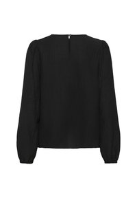Blouse noire à manches longues en tissu ribbé, avec un col rond et une fermeture éclair discrète à l'arrière.