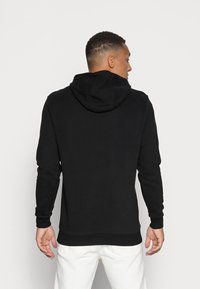 Zwarte hoodie van zachte stof, met een capuchon met trekkoord, lange mouwen, ribgebreide manchetten en een standaard pasvorm met een rechte zoom.