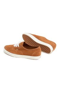 Baskets en suede marron avec des lacets blancs, bout rond et semelle en caoutchouc. Présentent un motif de texture antidérapant en dessous et le logo Vans sur le côté.