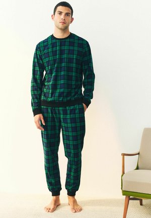 Grön och marinblå rutiga pyjamas-set i mjukt tyg, med svarta muddar och midja, avslappnad passform och jogger-stil på byxorna.