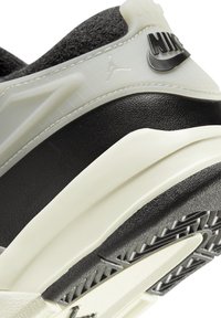Sneakers noirs et gris avec une tige texturée, une semelle en caoutchouc et de grands logos noirs de Nike et Jumpman. Comprend un accent crème lisse.