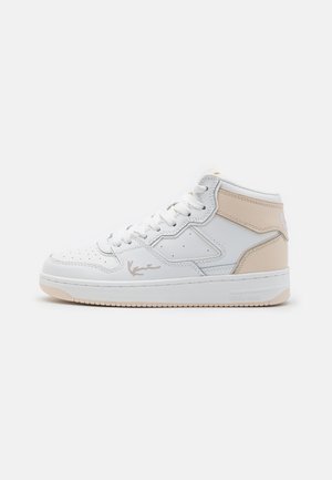Witte en beige hoge sneaker met veters aan de voorkant, geperforeerde neus en kenmerkend detail aan de zijkant, zijaanzicht op een effen achtergrond.