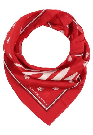 Écharpe en coton rouge pliée en forme de triangle avec des rayures blanches et noires ainsi que des motifs circulaires répétés, avec le logo Tommy Hilfiger.
