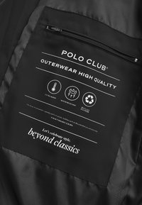 La etiqueta de la prenda exterior negra presenta el logo "POLO CLUB", instrucciones de cuidado e íconos para calor, resistencia al agua y material reciclado. Incluye un bolsillo con cremallera.