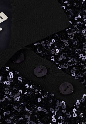 Black textured coat collar with three round buttons and densely packed shiny black sequins on fabric edges.