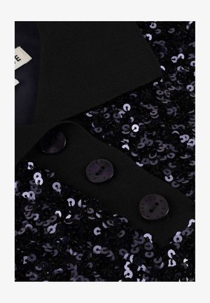 Zwarte textuur jas kraag met drie ronde knopen en dicht op elkaar geplaatste glanzende zwarte pailletten op de rand van de stof.