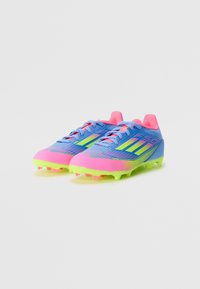 Blue and pink soccer cleats with neon green accents. Features a textured upper, lace closure, and multiple studs on the outsole for traction.