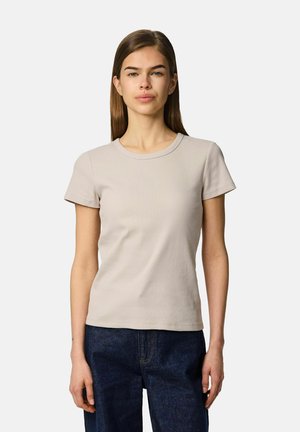 Beige ribbad t-shirt med rund halsringning och korta ärmar, parat med mörkblå jeans. Tyget verkar mjukt och något texturerat.