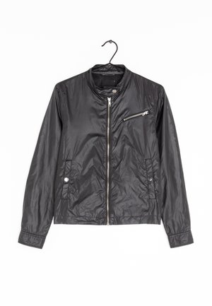 Veste légère en nylon noire avec fermeture éclair frontale, poche poitrine zippée, col à boutons-pression et deux poches latérales à boutons-pression suspendue sur un cintre noir.