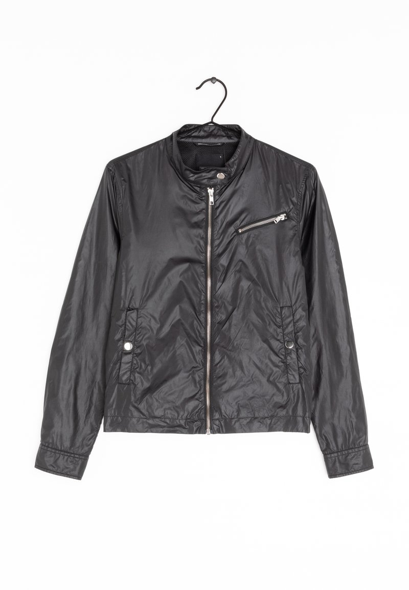 Veste légère en nylon noire avec fermeture éclair frontale, poche poitrine zippée, col à boutons-pression et deux poches latérales à boutons-pression suspendue sur un cintre noir.
