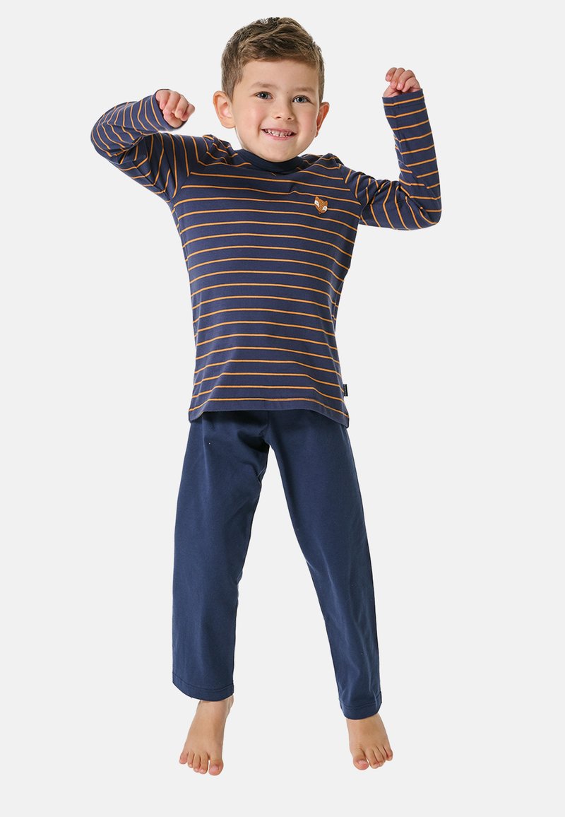 Navy long-sleeve shirt with orange stripes and a small fox emblem, paired with navy pants. Child jumps joyfully, barefoot.