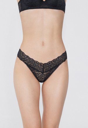 Zwarte kanten string met bloemenpatronen, gegolfde randen en minimale bedekking. Zachte textuur en elegante ontwerpkenmerken.