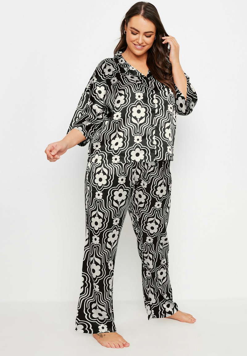 Svart och vit blommönstrad pyjamasset som har en löst sittande topp med krage och matchande byxor med raka ben. Mjuk tygkvalitet.