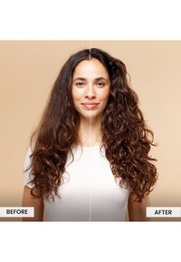 Capelli ricci mostrati in un'immagine divisa; lato sinistro crespo e poco definito, lato destro ricci definiti, texture lucida. Carnagione chiara, sfondo neutro.