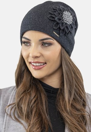 Gorro gris con tejido texturizado, presenta un aplique de flor de fieltro con acentos de rhinestone en el lateral. Material suave, ajuste ceñido.