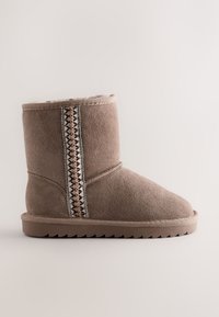 Stivale invernale in camoscio marrone di altezza media con morbida fodera in pelliccia e motivo decorativo a cuciture verticali sul lato, suola piatta in gomma antiscivolo.