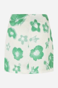 Jupe mini florale en tissu texturé et froissé. Motif de fleurs vertes et blanches, présentant différentes nuances de vert sur un fond clair.