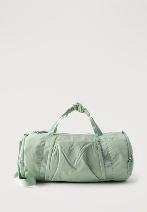 Light green Nike duffel bag with dual handles and adjustable shoulder strap, featuring zippered compartments and the Nike logo on the front pocket.